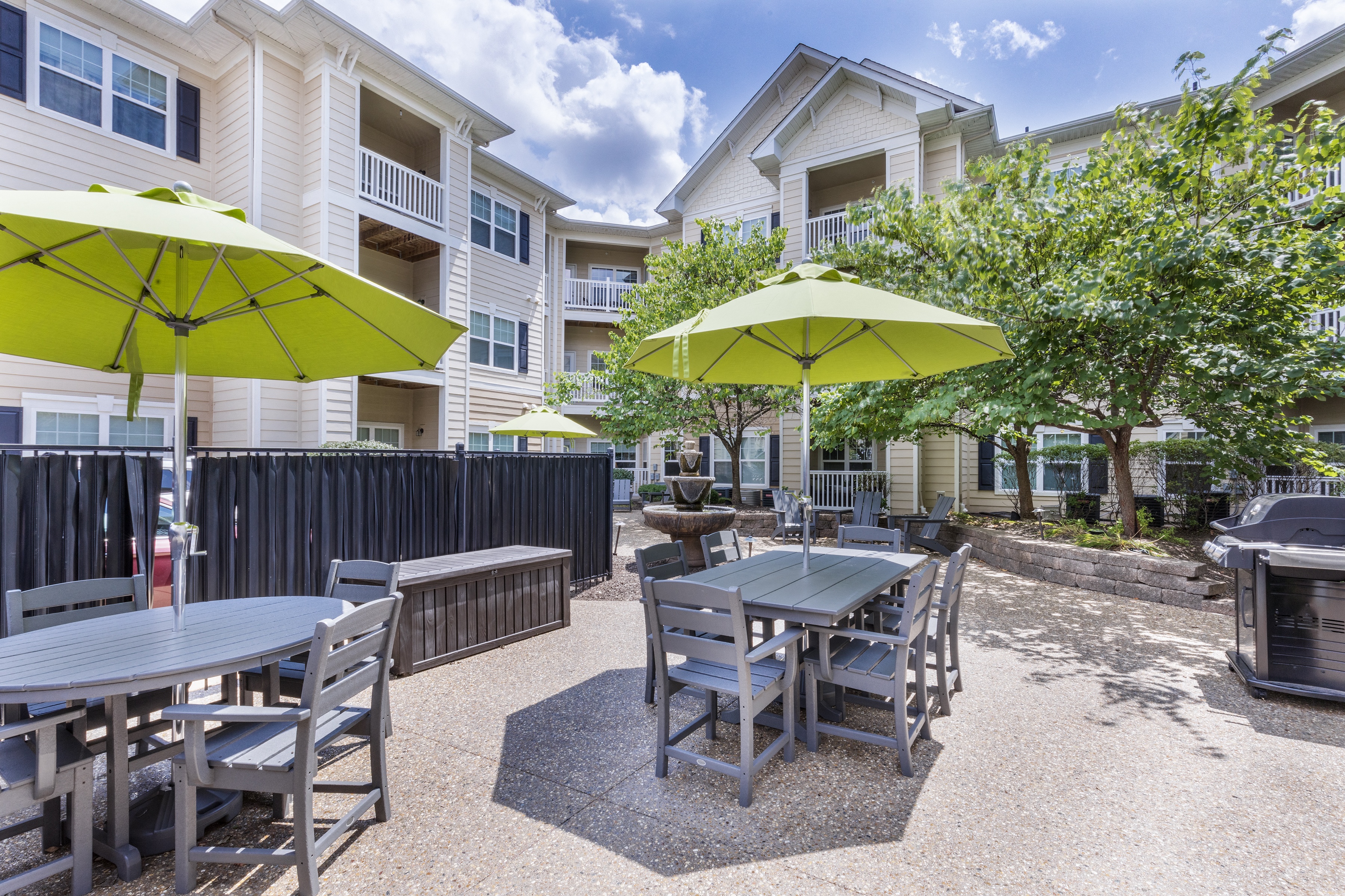 our yard with tables and chairs and umbrellas at our apartments on the strip at Aventura at Forest Park, St. Louis,Missouri